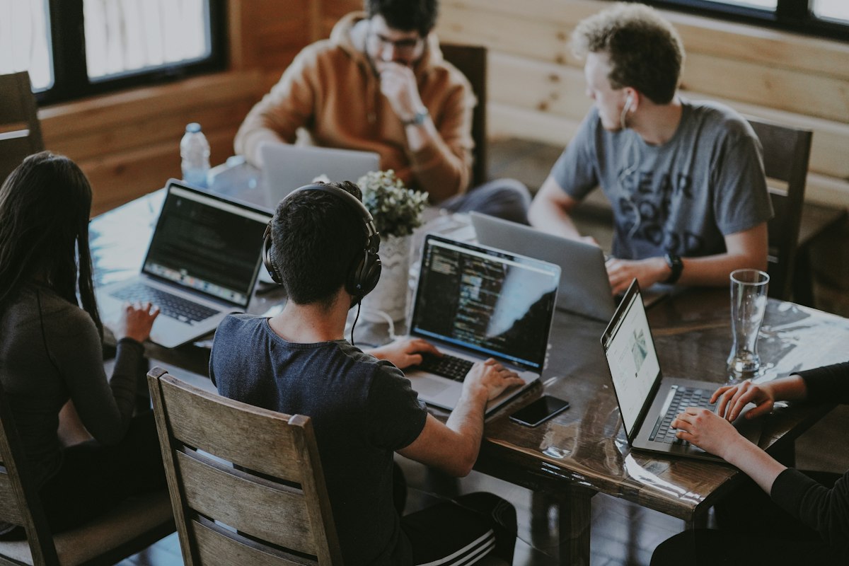 Equipo de trabajo reunido con computadoras portátiles; imagen ilustrativa